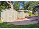 The backyard offers a storage shed and detached flex space with hardscaped patio surrounded by lush greenery at 3118 Walnut St, Winter Haven, FL 33881