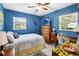 Cozy bedroom featuring blue walls, wood dresser, white tile floors, and a bright window at 3118 Walnut St, Winter Haven, FL 33881