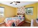 Bright bedroom showcasing a queen bed with floral bedding and two windows for plenty of light at 3118 Walnut St, Winter Haven, FL 33881
