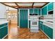 Spacious kitchen with custom colored cabinets, white appliances, and hardwood flooring at 3118 Walnut St, Winter Haven, FL 33881