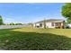 Large backyard with grass, mature trees, patio area, and a fence, offering privacy and space at 3270 Courtland Blvd, Deltona, FL 32738