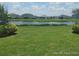 A lovely backyard featuring a serene pond view, lush green grass, and sunny skies at 356 Quarry Rock Cir, Kissimmee, FL 34758