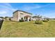 A wide shot of a backyard with green grass and landscaping, and view of the home's rear exterior at 356 Quarry Rock Cir, Kissimmee, FL 34758