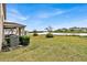 Spacious backyard with a view of the water, a covered porch, and healthy green grass at 356 Quarry Rock Cir, Kissimmee, FL 34758