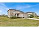 Side view of a two-story home showing the lawn and a two-car garage on a sunny day at 356 Quarry Rock Cir, Kissimmee, FL 34758