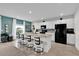 Bright kitchen features white cabinets, an island with seating, and a black refrigerator at 356 Quarry Rock Cir, Kissimmee, FL 34758