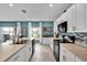 This eat-in kitchen has white cabinets, stainless appliances, a light countertop, and a mosaic backsplash at 356 Quarry Rock Cir, Kissimmee, FL 34758