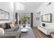 Bright living room features a gray sofa, balcony, and wood floors at 3900 Southpointe Dr # 127, Orlando, FL 32822