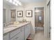 Well-lit bathroom with double vanity, granite counters, and glass-enclosed shower at 4314 Lana Ave, Davenport, FL 33897