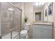 Bathroom with shower, granite vanity, white cabinets, toilet and neutral color palette at 4314 Lana Ave, Davenport, FL 33897