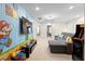 Spacious carpeted game room boasts Super Mario themed-wall art, sectional sofa, television, and arcade game at 4314 Lana Ave, Davenport, FL 33897