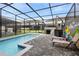 Lovely view of the pool with lounge chairs and screened lanai that is perfect for entertaining at 4314 Lana Ave, Davenport, FL 33897