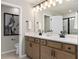 Bathroom featuring double vanity, sleek fixtures, and decorative black and white abstract art at 4564 Maple Waltz Aly, Clermont, FL 34714