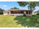 Backyard view of the home with a screened-in porch and a well-maintained lawn at 4930 Gifford Blvd, Orlando, FL 32821