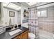 Cozy bathroom features a vanity, decorated shelves, and a tub with a seashell-themed shower curtain at 4930 Gifford Blvd, Orlando, FL 32821