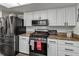 Kitchen boasts stainless steel appliances, white cabinets and granite countertops at 4930 Gifford Blvd, Orlando, FL 32821