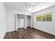 Bright bedroom features dark wood floors, a ceiling fan, and a large window overlooking a verdant yard at 611 Lakespur Ln, Altamonte Springs, FL 32714