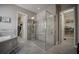 Spacious bathroom featuring a glass-enclosed shower, soaking tub, and access to walk-in closets at 7536 Green Mountain Way, Winter Garden, FL 34787