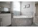 Elegant bathroom featuring a large soaking tub with tile surround and stylish fixtures at 7536 Green Mountain Way, Winter Garden, FL 34787