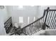 View from the stairs landing of the entryway with large shelving, seating, and a dark wood-and-metal banister at 7536 Green Mountain Way, Winter Garden, FL 34787