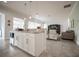 White kitchen island with breakfast bar, granite counters, stainless steel dishwasher, and open layout to the living area at 7536 Green Mountain Way, Winter Garden, FL 34787