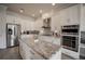 Bright kitchen featuring white cabinetry, granite countertops, an island, and stainless steel appliances at 7536 Green Mountain Way, Winter Garden, FL 34787