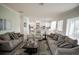 Inviting living area showcasing sofas, flowing into a modern white kitchen creating an open and airy living space at 7536 Green Mountain Way, Winter Garden, FL 34787