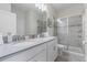 Bathroom with double sinks, light countertops, white cabinets, and a glass-enclosed shower at 8833 Cruden Bay Ct, Davenport, FL 33896
