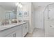 A modern bathroom features double sinks, white cabinetry, and a glass-enclosed shower at 8833 Cruden Bay Ct, Davenport, FL 33896