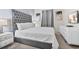 Comfortable bedroom featuring a tufted headboard, white linens and grey carpet at 8833 Cruden Bay Ct, Davenport, FL 33896