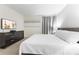 A bedroom features a neutral color scheme, a TV, artwork, and a black dresser at 8833 Cruden Bay Ct, Davenport, FL 33896