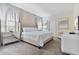 Elegant bedroom with a tufted headboard, mirrored nightstand, and plush carpeting at 8833 Cruden Bay Ct, Davenport, FL 33896