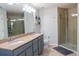 Bathroom featuring a double sink vanity, neutral tile and a glass shower enclosure at 9575 Silver Buttonwood St, Orlando, FL 32832