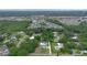 Wide aerial view of the neighborhood with lush trees, community streets and a glimpse of a nearby lake at 103 Longhorn Rd, Winter Park, FL 32792