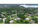 Scenic overhead shot of a neighborhood near a lake and lush greenery, capturing homes with pools at 103 Longhorn Rd, Winter Park, FL 32792