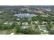 Overhead shot of a neighborhood near a lake, surrounded by lush greenery and scattered homes with pools at 103 Longhorn Rd, Winter Park, FL 32792