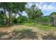 Large backyard with some grass, trees and pool enclosure at 103 Longhorn Rd, Winter Park, FL 32792