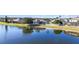 Backyard with a lake view features a white fence, a lawn, and beautiful landscaping at 10642 Cloudview Dr, Orlando, FL 32825