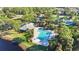 Bird's eye view of community pool, tennis court, playground, parking, and lush landscaping by a lake at 10642 Cloudview Dr, Orlando, FL 32825