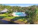 Aerial view of a community pool with seating and clubhouse near palm trees and a lake at 10642 Cloudview Dr, Orlando, FL 32825