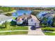 Beautiful lakefront home with lush lawn, brick driveway, and attached two-car garage at 10642 Cloudview Dr, Orlando, FL 32825