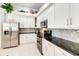 Well-lit kitchen featuring white cabinets, stainless steel appliances, and granite countertops at 10642 Cloudview Dr, Orlando, FL 32825