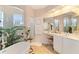 Spa-like main bathroom featuring a soaking tub, walk-in shower, and vanity area at 10642 Cloudview Dr, Orlando, FL 32825