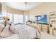Spacious main bedroom featuring a tray ceiling, seating area, and large television at 10642 Cloudview Dr, Orlando, FL 32825