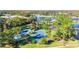 Aerial view of community tennis courts and amenities surrounded by lush landscaping and a beautiful lake at 10642 Cloudview Dr, Orlando, FL 32825