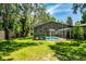A large grassy backyard with a screened in-ground swimming pool at 112 Brandywine Ln, Longwood, FL 32779