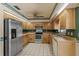 Functional kitchen equipped with stainless steel appliances, light wood cabinets, and tile flooring for easy maintenance at 112 Brandywine Ln, Longwood, FL 32779