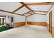Open living room with exposed beam ceilings, backyard access, and a combination of carpet and wood paneling at 112 Brandywine Ln, Longwood, FL 32779