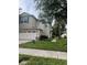 Two-story home with two-car garage, brick paver driveway, and lawn at 1122 Priory Cir, Winter Garden, FL 34787
