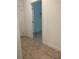 Hallway with tile flooring leading to unfinished rooms with an open door at 14741 Milfoil Ave, Orlando, FL 32827
